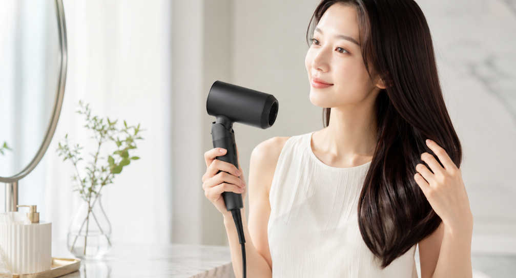 マットブラックの87sakuヘアドライヤーでツヤのある髪を整える日本人女性