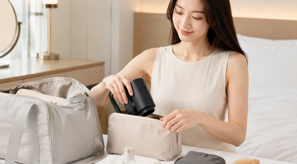 コンパクトな87sakuヘアドライヤーを旅行用ポーチに収納する日本人女性