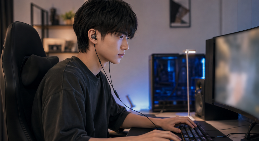 有線ゲーミングIEMを装着してPCゲームをプレイする日本人男性のFSF Blink Bound BD01使用イメージ
