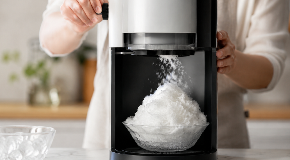 電動かき氷器で氷を薄く削り、ふわふわのかき氷を作っている様子